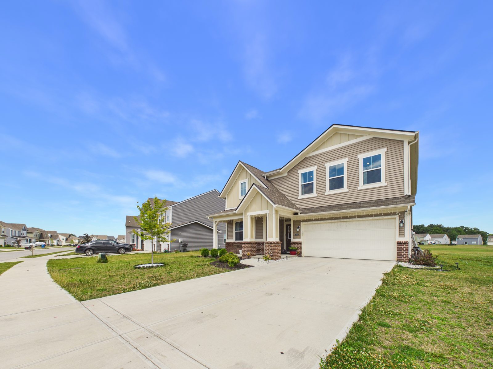 Two-story house exterior with a driveway and lawn